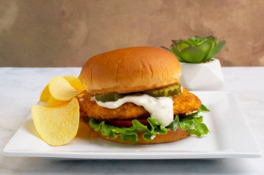  Hamburg çöreğinde servis edilen marul, domates ve turşulu tavuk göğsü.