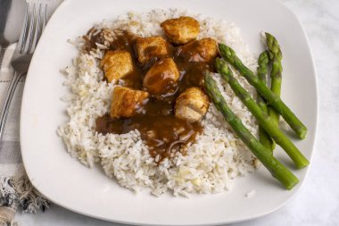 Sarımsaklı beyaz pirinç ve tavuk ısırığı soslu soğan.