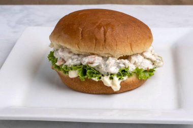 Çöreğin üzerinde marullu karides deniz ürünleri salatası.