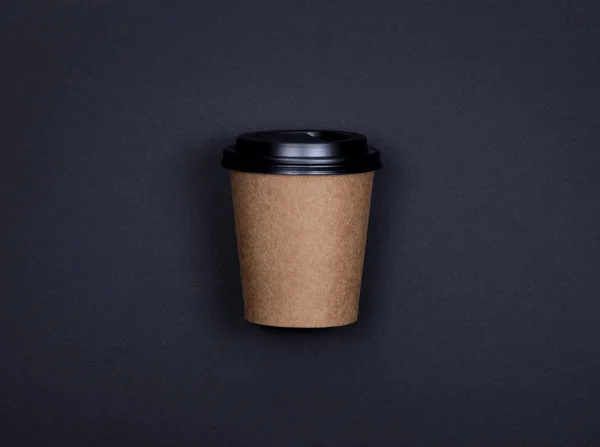 Taza de papel de artesanía marrón simple de café para ir sobre fondo negro con espacio de copia . —  Fotos de Stock