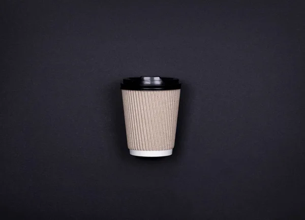 Taza de papel de artesanía marrón simple de café para ir sobre fondo negro con espacio de copia . — Foto de Stock