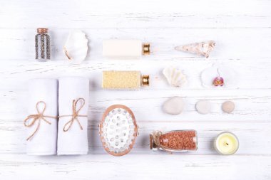 Beyaz ahşap zemin üzerinde farklı spa, güzellik ve sağlık ürünleri bileşimi. 
