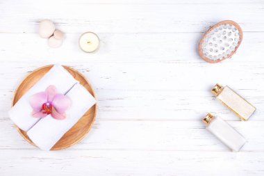 Beyaz ahşap zemin üzerinde farklı spa, güzellik ve sağlık ürünleri bileşimi. 