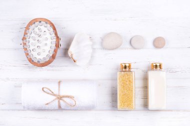 Beyaz ahşap zemin üzerinde farklı spa, güzellik ve sağlık ürünleri bileşimi. 
