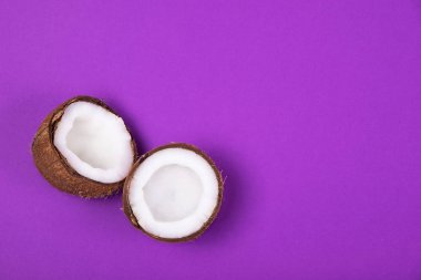 Menekşe mor arka planda yarım olgun Hindistan cevizi üst görünümü. Boşluk Kopyala.