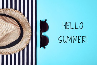 Çizgili elbiseler, güneş gözlüğü ve pembe bir arka plan üzerinde hasır şapka. Üstten görünüm. Düz yatıyordu.