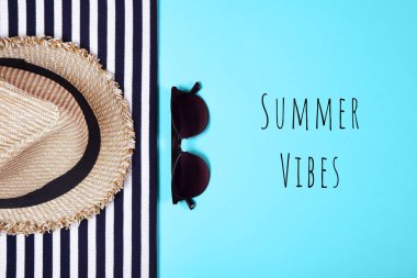 Çizgili elbiseler, güneş gözlüğü ve pembe bir arka plan üzerinde hasır şapka. Üstten görünüm. Düz yatıyordu.