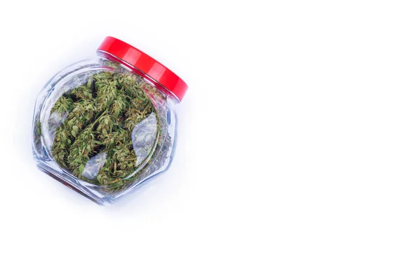 Brotes verdes frescos o flores de marihuana de cannabis en un frasco de vidrio transparente aislado sobre fondo blanco . — Foto de Stock