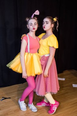 Yaratıcı bir mini stüdyoda çocuk gösterisi. Renkli kıyafetler giyen çocuklar performans gösterir. Bir sürü duygu. Şenlikli atmosfer.