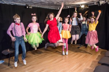 Yaratıcı bir mini stüdyoda çocuk gösterisi. Renkli kıyafetler giyen çocuklar performans gösterir. Bir sürü duygu. Şenlikli atmosfer.  