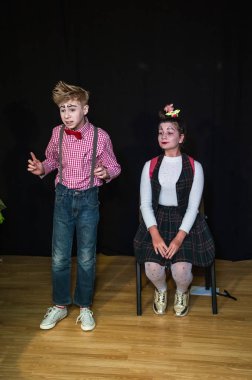 Yaratıcı bir mini stüdyoda çocuk gösterisi. Renkli kıyafetler giyen çocuklar performans gösterir. Bir sürü duygu. Şenlikli atmosfer.  