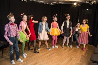 Yaratıcı bir mini stüdyoda çocuk gösterisi. Renkli kıyafetler giyen çocuklar performans gösterir. Bir sürü duygu. Şenlikli atmosfer.  