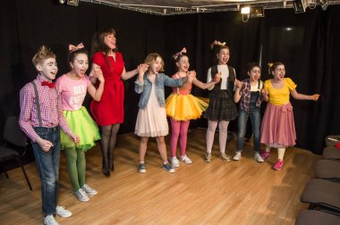 Yaratıcı bir mini stüdyoda çocuk gösterisi. Renkli kıyafetler giyen çocuklar performans gösterir. Bir sürü duygu. Şenlikli atmosfer.  