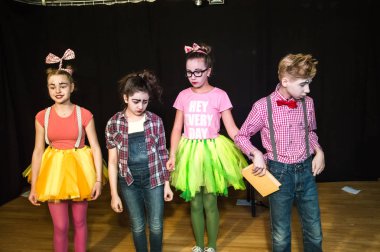 Yaratıcı bir mini stüdyoda çocuk gösterisi. Renkli kıyafetler giyen çocuklar performans gösterir. Bir sürü duygu. Şenlikli atmosfer.  