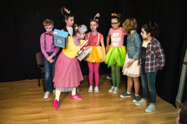 Yaratıcı bir mini stüdyoda çocuk gösterisi. Renkli kıyafetler giyen çocuklar performans gösterir. Bir sürü duygu. Şenlikli atmosfer.  