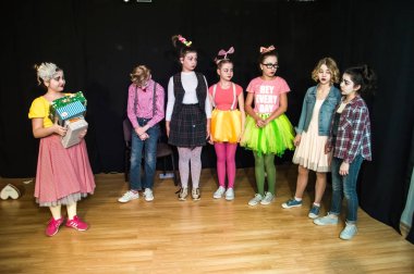 Yaratıcı bir mini stüdyoda çocuk gösterisi. Renkli kıyafetler giyen çocuklar performans gösterir. Bir sürü duygu. Şenlikli atmosfer.  