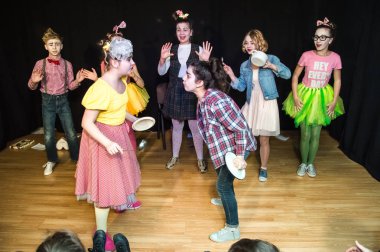 Yaratıcı bir mini stüdyoda çocuk gösterisi. Renkli kıyafetler giyen çocuklar performans gösterir. Bir sürü duygu. Şenlikli atmosfer.  