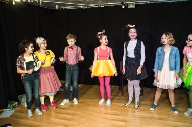 Yaratıcı bir mini stüdyoda çocuk gösterisi. Renkli kıyafetler giyen çocuklar performans gösterir. Bir sürü duygu. Şenlikli atmosfer.  