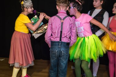 Yaratıcı bir mini stüdyoda çocuk gösterisi. Renkli kıyafetler giyen çocuklar performans gösterir. Bir sürü duygu. Şenlikli atmosfer.  