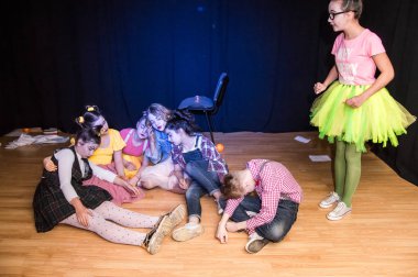 Yaratıcı bir mini stüdyoda çocuk gösterisi. Renkli kıyafetler giyen çocuklar performans gösterir. Bir sürü duygu. Şenlikli atmosfer.