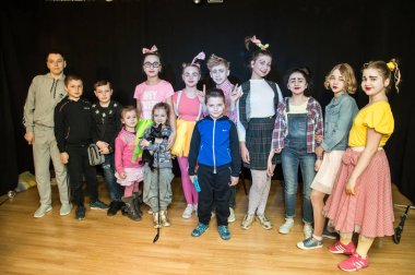 Yaratıcı bir mini stüdyoda çocuk gösterisi. Renkli kıyafetler giyen çocuklar performans gösterir. Bir sürü duygu. Şenlikli atmosfer.