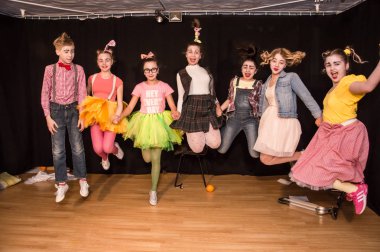 Yaratıcı bir mini stüdyoda çocuk gösterisi. Renkli kıyafetler giyen çocuklar performans gösterir. Bir sürü duygu. Şenlikli atmosfer.