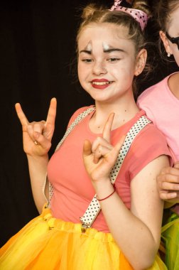 Yaratıcı bir mini stüdyoda çocuk gösterisi. Renkli kıyafetler giyen çocuklar performans gösterir. Bir sürü duygu. Şenlikli atmosfer.