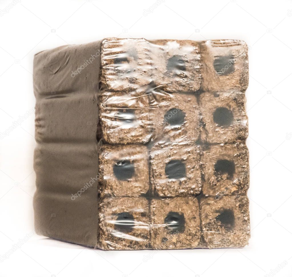 Fuel briquettes folded in rows on a white background. Wooden  briquettes are an environmentally friendly fuel source that are used to start a fire. They are made by pressing of dry sawdust.