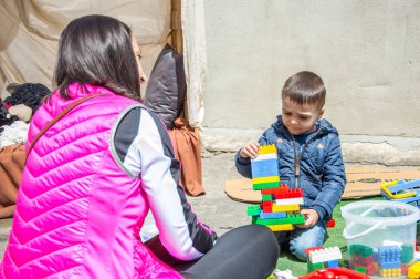 Çocuklar ve ebeveynler için açık etkinlik. Yetişkinler ve çocuklar dinlenir, tatlı yer, müzik dinler ve oyun oynarlar. Gülümseyen insanların portreleri.  
