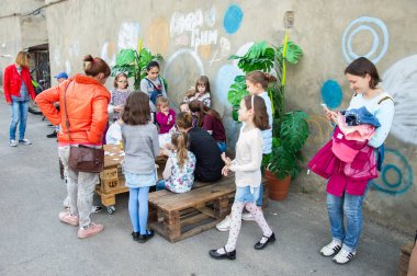 Çocuklar ve ebeveynler için açık etkinlik. Yetişkinler ve çocuklar dinlenir, tatlı yer, müzik dinler ve oyun oynarlar. Gülümseyen insanların portreleri.  