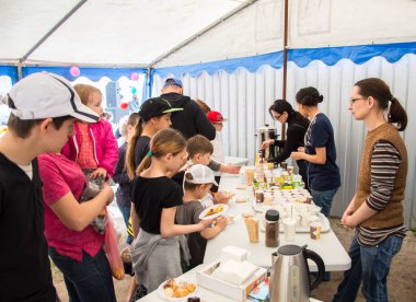 Çocuklar ve ebeveynler için açık etkinlik. Yetişkinler ve çocuklar dinlenir, tatlı yer, müzik dinler ve oyun oynarlar. Gülümseyen insanların portreleri.  