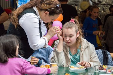 Çocuklar ve ebeveynler için açık etkinlik. Yetişkinler ve çocuklar dinlenir, tatlı yer, müzik dinler ve oyun oynarlar. Gülümseyen insanların portreleri.  