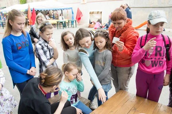 Çocuklar ve ebeveynler için açık etkinlik. Yetişkinler ve çocuklar dinlenir, tatlı yer, müzik dinler ve oyun oynarlar. Gülümseyen insanların portreleri.  