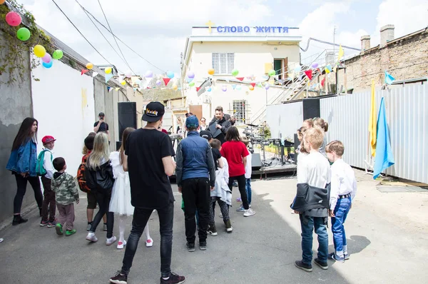 Çocuklar ve ebeveynler için açık etkinlik. Yetişkinler ve çocuklar dinlenir, tatlı yer, müzik dinler ve oyun oynarlar. Gülümseyen insanların portreleri.  