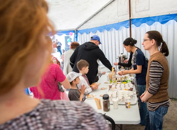 Çocuklar ve ebeveynler için açık etkinlik. Yetişkinler ve çocuklar dinlenir, tatlı yer, müzik dinler ve oyun oynarlar. Gülümseyen insanların portreleri.  