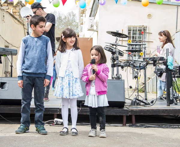 Çocuklar ve ebeveynler için açık etkinlik. Yetişkinler ve çocuklar dinlenir, tatlı yer, müzik dinler ve oyun oynarlar. Gülümseyen insanların portreleri.  