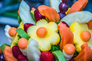 Meyve buketi yapma süreci. Bu düzenlemeler ve çikolata daldırma meyve için taze meyve kesme içerir.