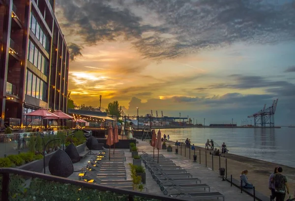 Sunset by the sea. Beautiful buildings and the port. — Stock Photo, Image