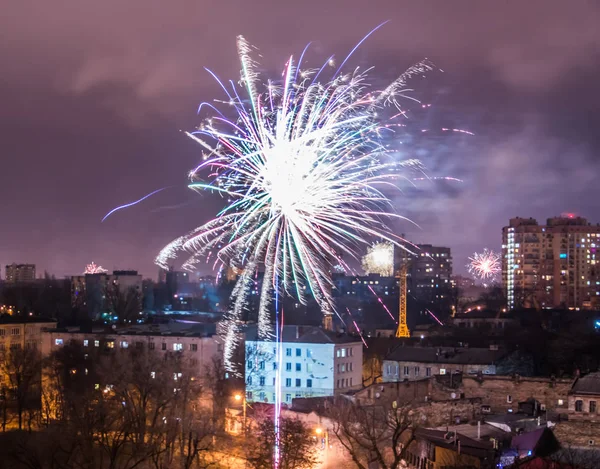 Fuegos artificiales en la víspera de Año Nuevo sobre la ciudad . — Foto de Stock
