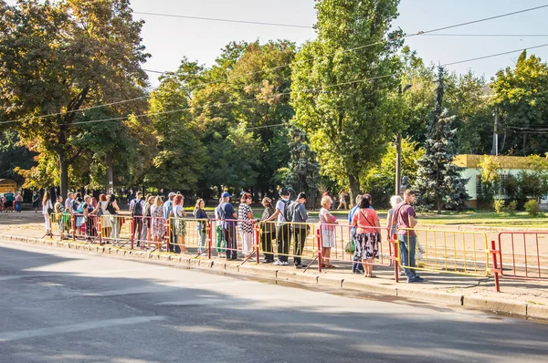 Insanlar otobüs durağında duran ve tramvay bekliyor. Kamu
