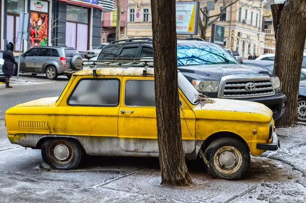 Vieja máquina amarilla y un Toyota grande aparcado cerca . —  Fotos de Stock