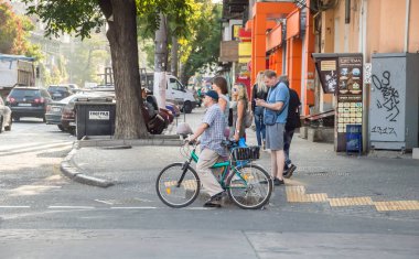 İnsanlar bisikletle çalışacak. Sokak, yol, arabalar.