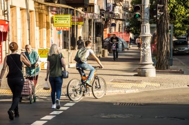 İnsanlar bisikletle çalışacak. Sokak, yol, arabalar.