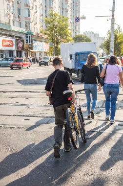 İnsanlar bisikletle çalışacak. Sokak, yol, arabalar.
