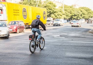 İnsanlar bisikletle çalışacak. Sokak, yol, arabalar.