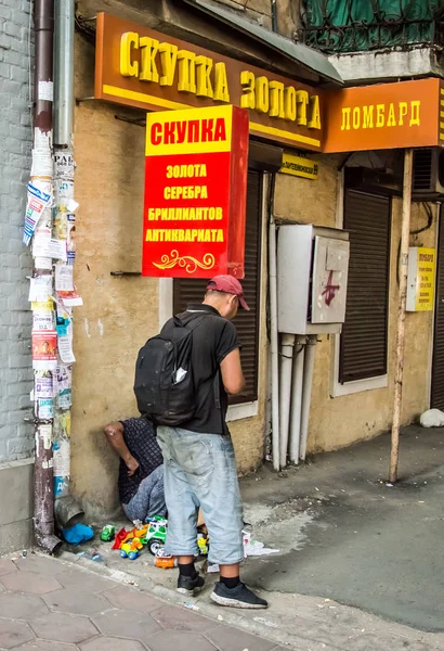 Un mendigo vende viejos juguetes de plástico en la calle . —  Fotos de Stock