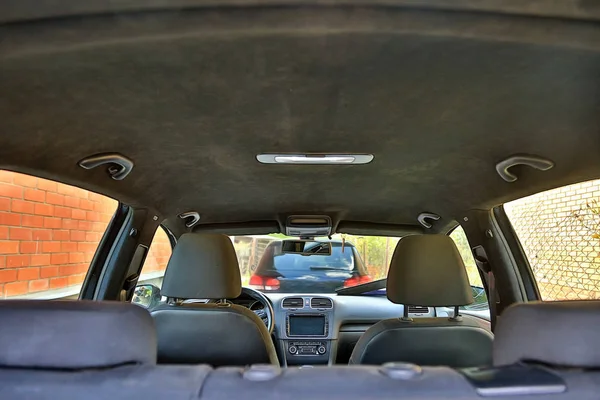 Parked cars at home. View from inside the car. Interior of a modern car with black alcantara ceiling