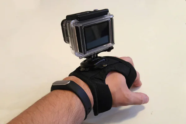 The action camera is fixed on the glove on the man\'s hand. On a white background