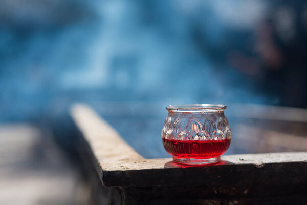Red candle in a glass on an incense burner