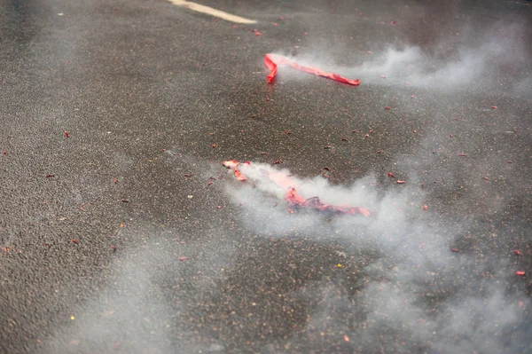 Rode voetzoekers exploderende met rook op het asfalt — Stockfoto